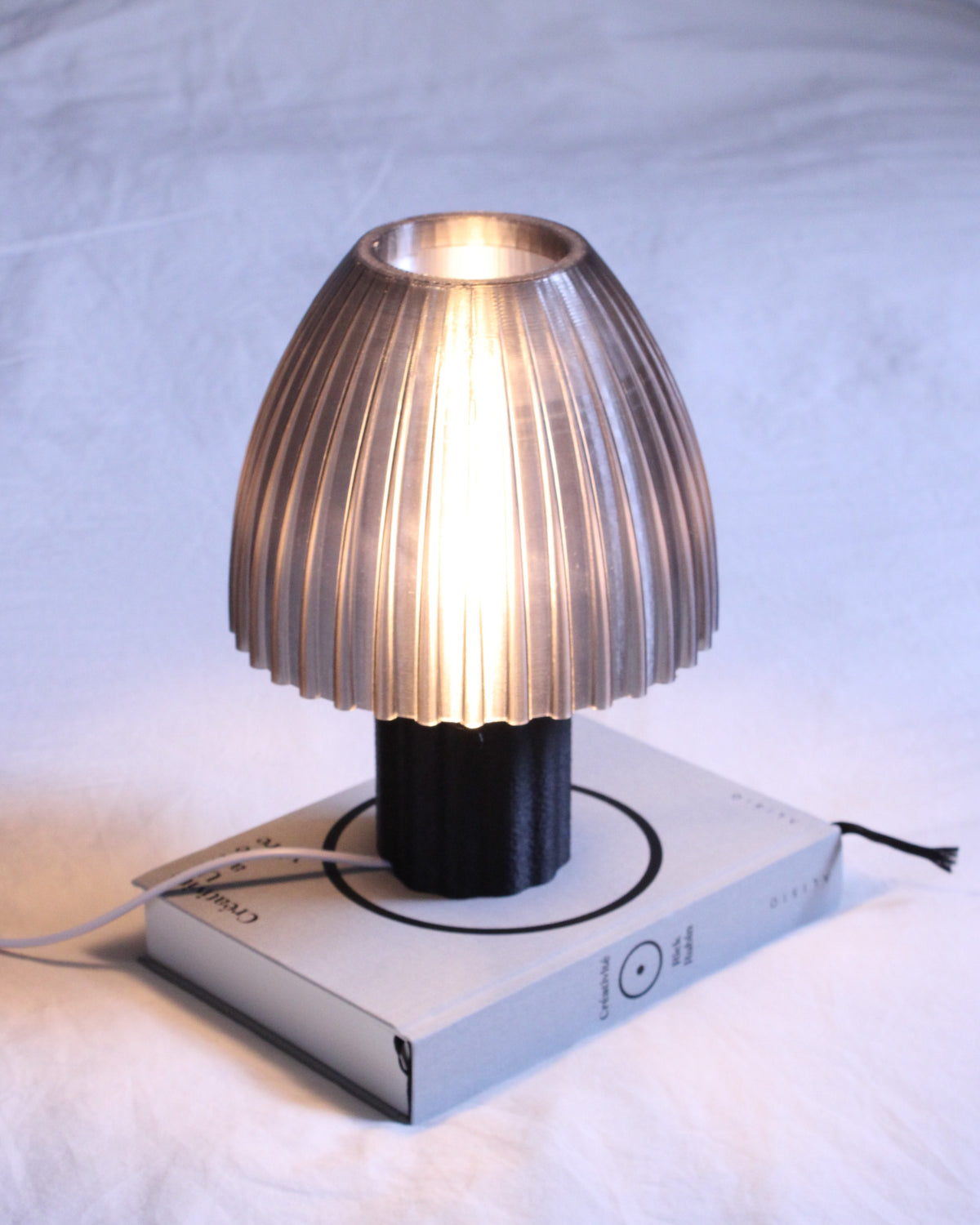 Lampe à poser design Mirbola Black noir mat allumée en ambiance, fabrication française